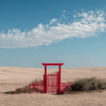 Isolated Crimson Gate on the Sandy Dune